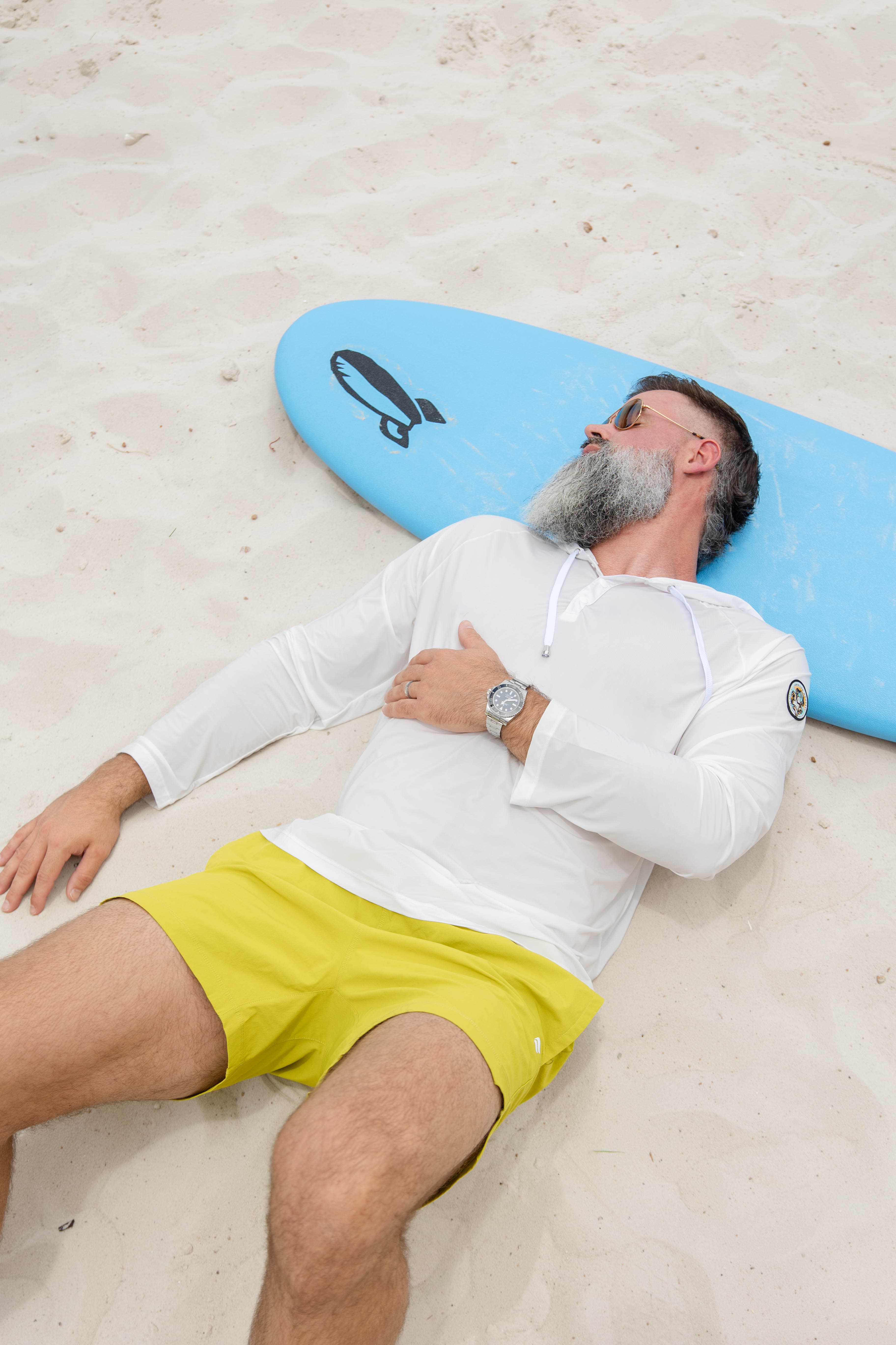 Man in Coconut Cloud hoodie with surfboard