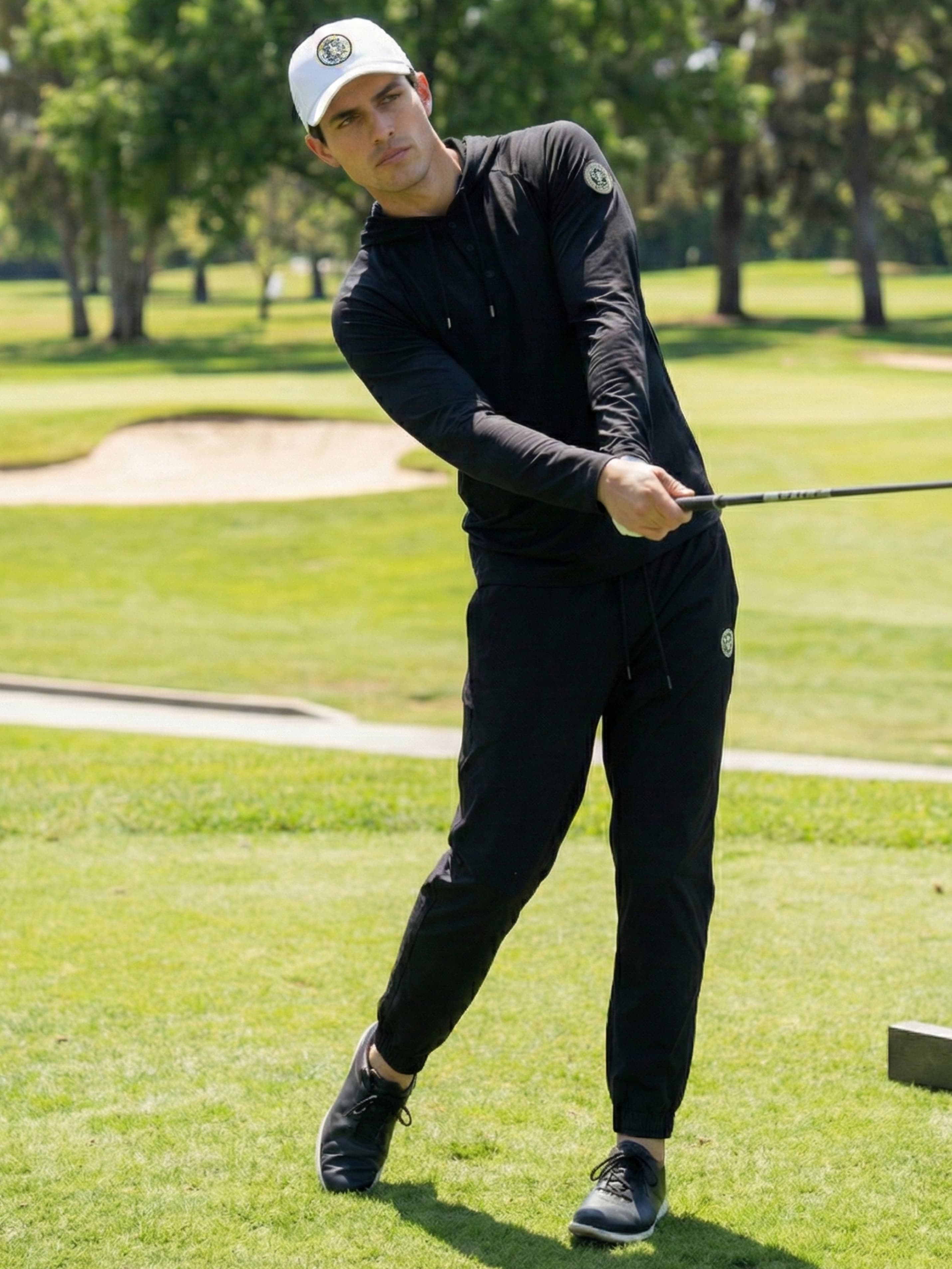 Man in black joggers playing golf