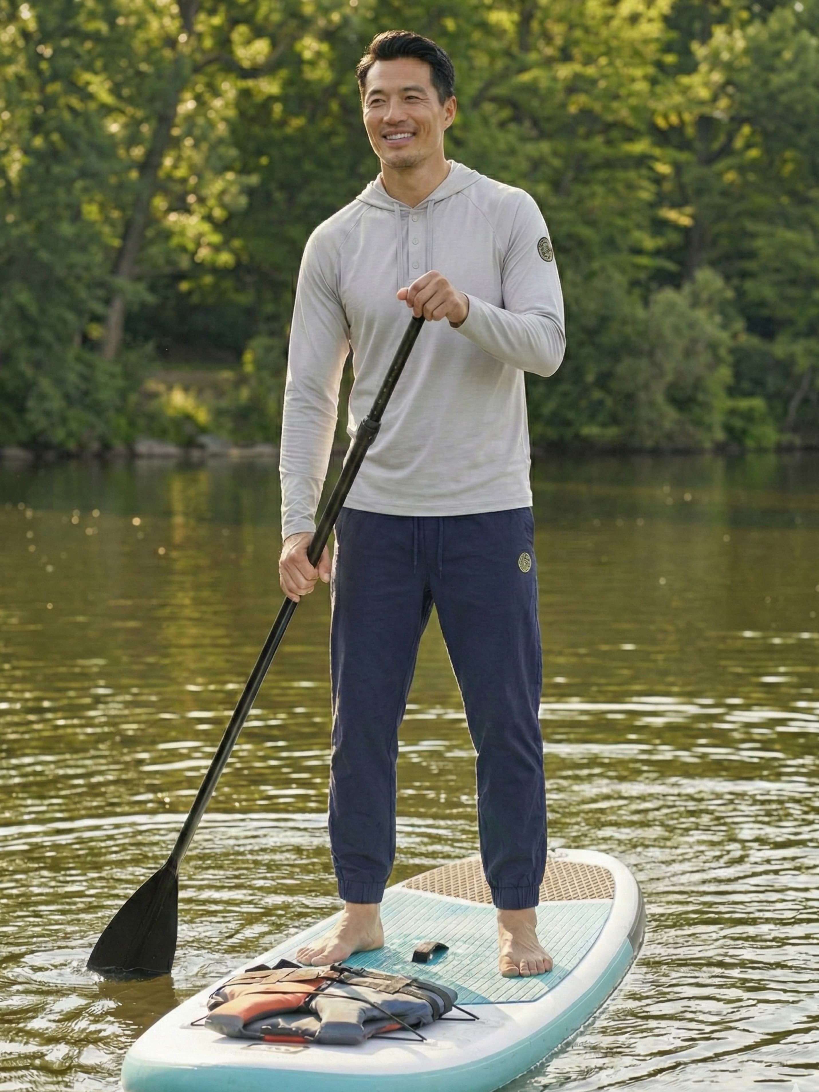 Man in navy joggers paddleboarding