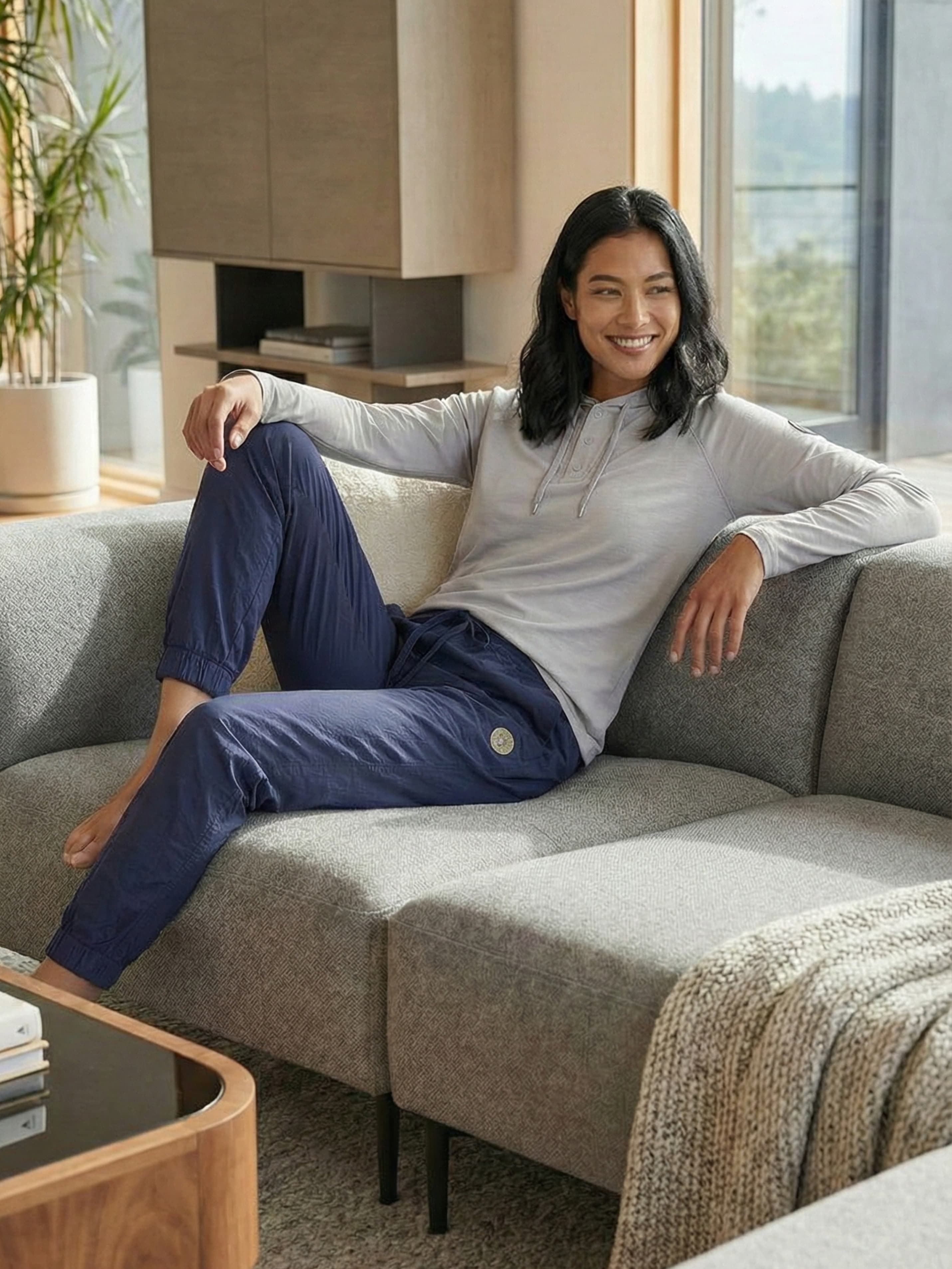 Woman relaxing on couch in navy joggers