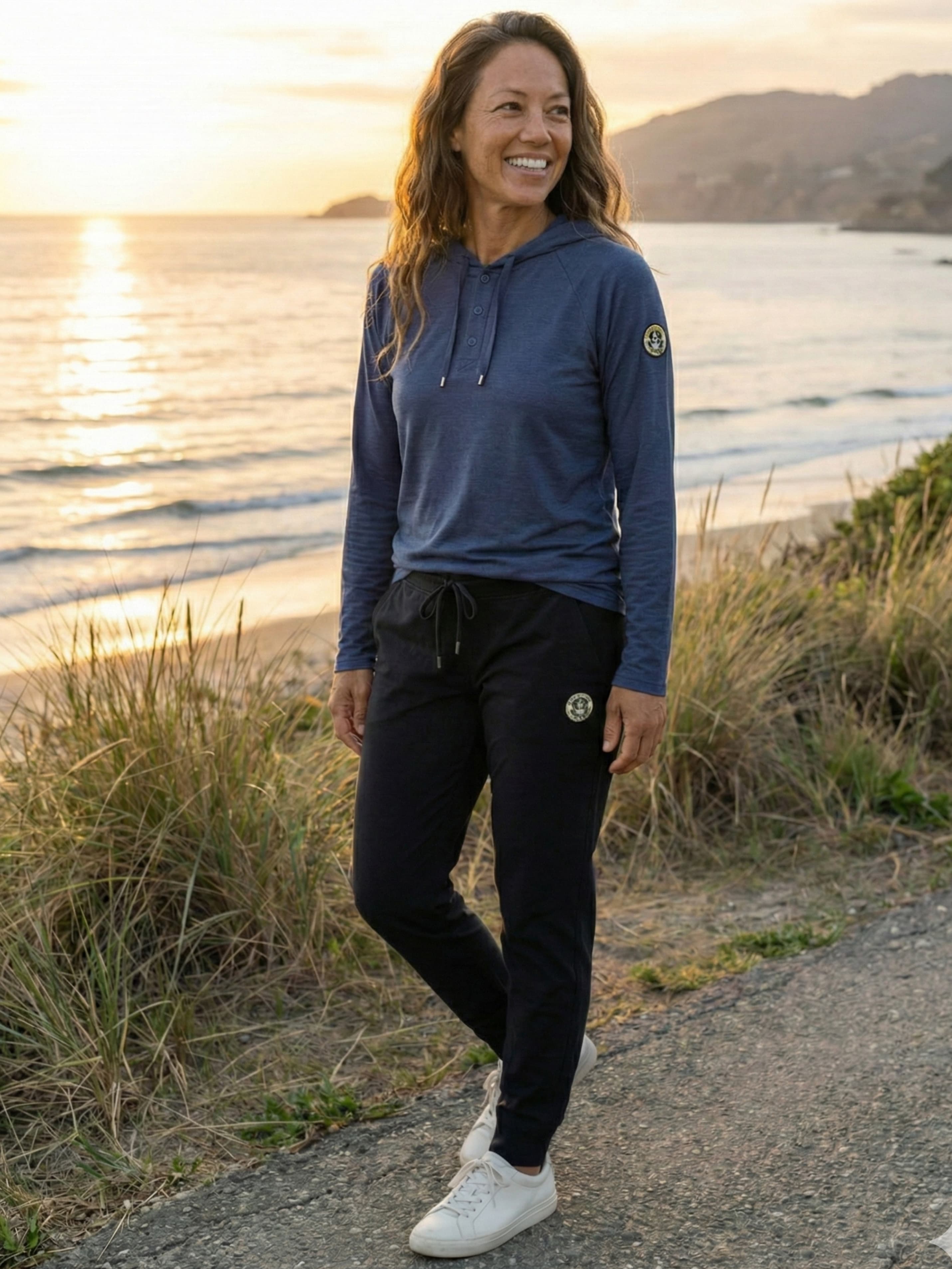 Woman in black joggers at sunset coastal trail